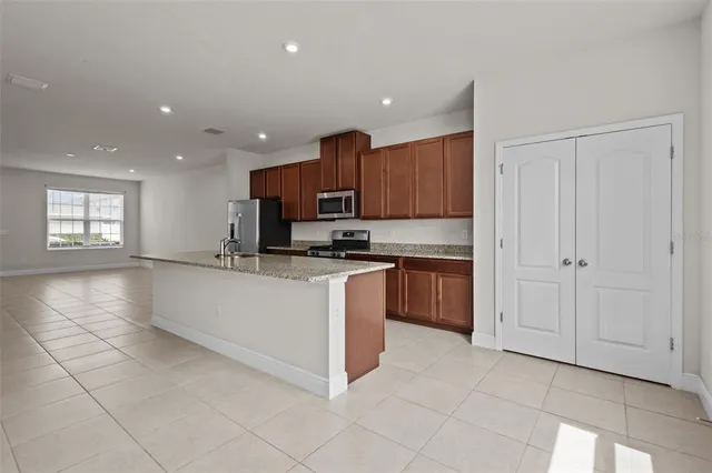 a kitchen with stainless steel appliances granite countertop a stove a sink and a refrigerator