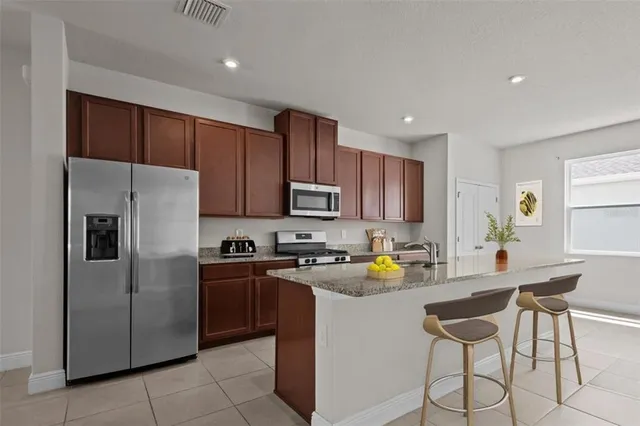 a kitchen with a refrigerator a stove a sink a counter top space and cabinets
