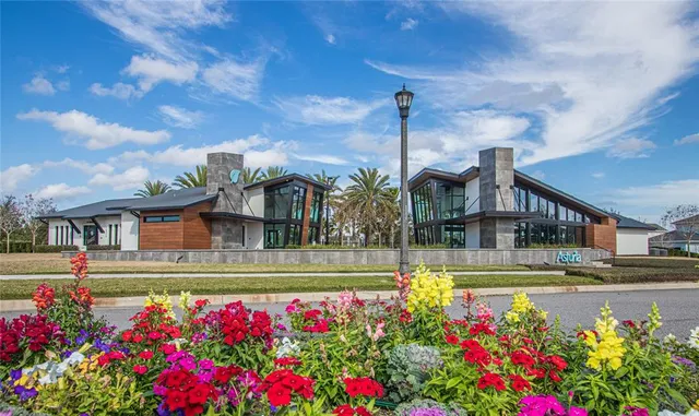 a front view of multi story residential apartment building with yard and flowers