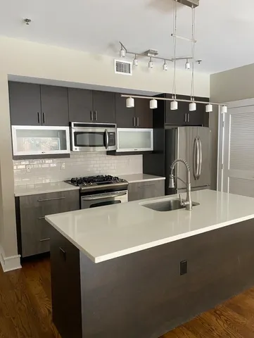 a kitchen with a sink a stove and cabinets