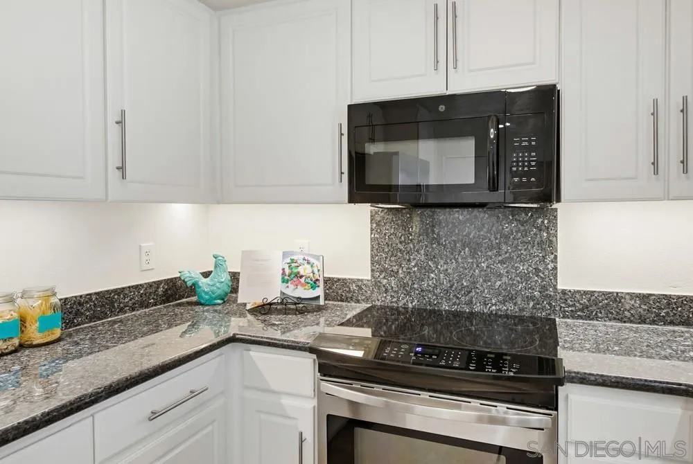 9229 Regents Road, Unit L206 La Jolla, CA 92037 - Photo 9 of 29 a kitchen with granite countertop white cabinets and stainless steel appliances