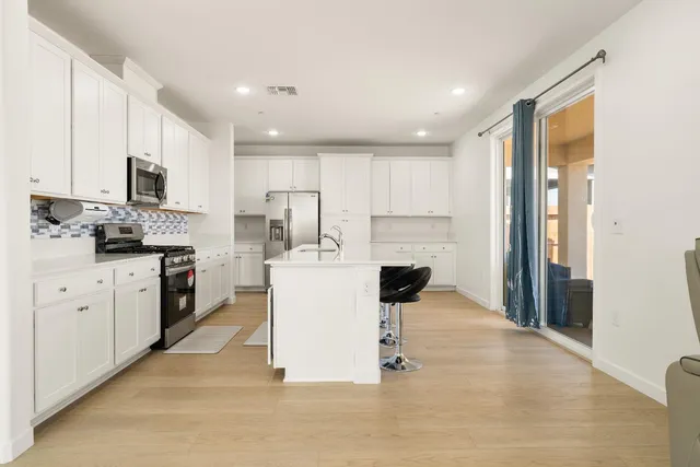 a kitchen with kitchen island granite countertop a sink appliances cabinets and a counter top space