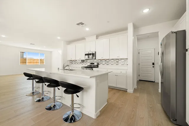 a kitchen with stainless steel appliances a sink a stove and microwave