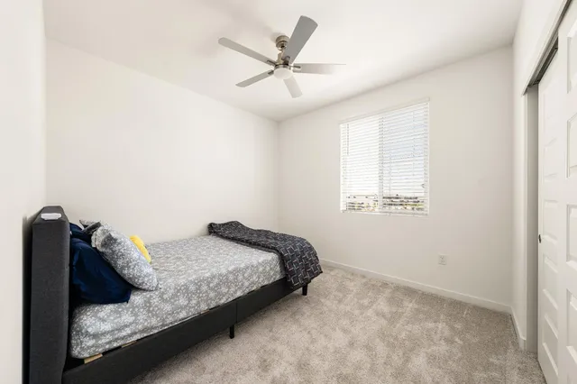 a bedroom with a bed and ceiling fan