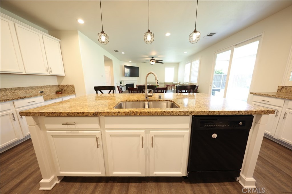 3848 Vine Maple Road San Bernardino, CA 92407 - Photo 3 of 25 a kitchen with kitchen island granite countertop a sink window and cabinets