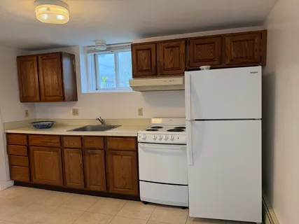 a kitchen with a refrigerator sink and cabinets