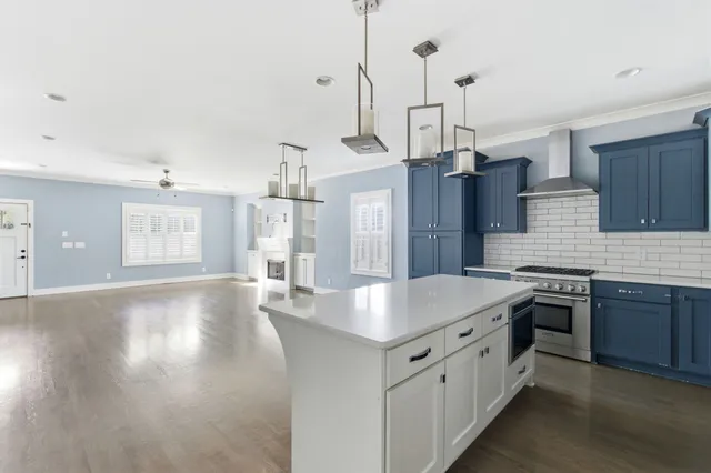 a kitchen with stainless steel appliances granite countertop a sink a stove a refrigerator and island