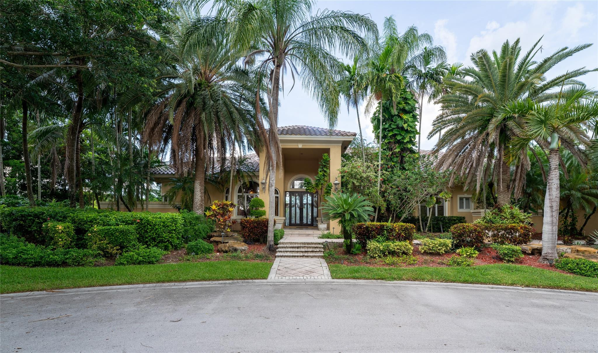 3220 Paddock Road Weston, FL 33331 - Photo 3 of 59 a front view of house with small garden and palm trees
