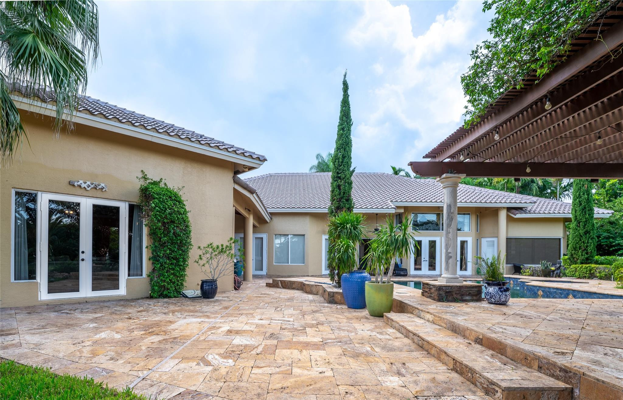 3220 Paddock Road Weston, FL 33331 - Photo 38 of 59 a view of a house with backyard sitting area and porch