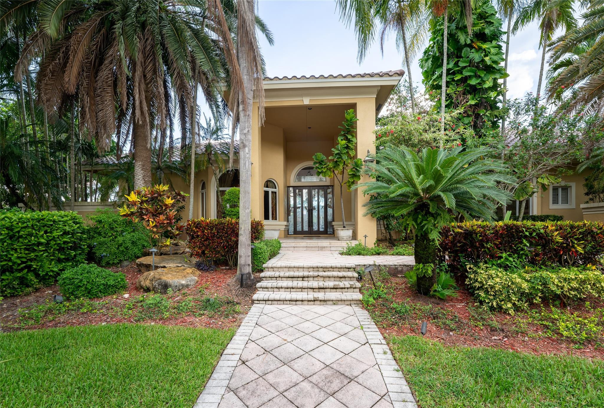 3220 Paddock Road Weston, FL 33331 - Photo 51 of 59 a front view of a house with a garden