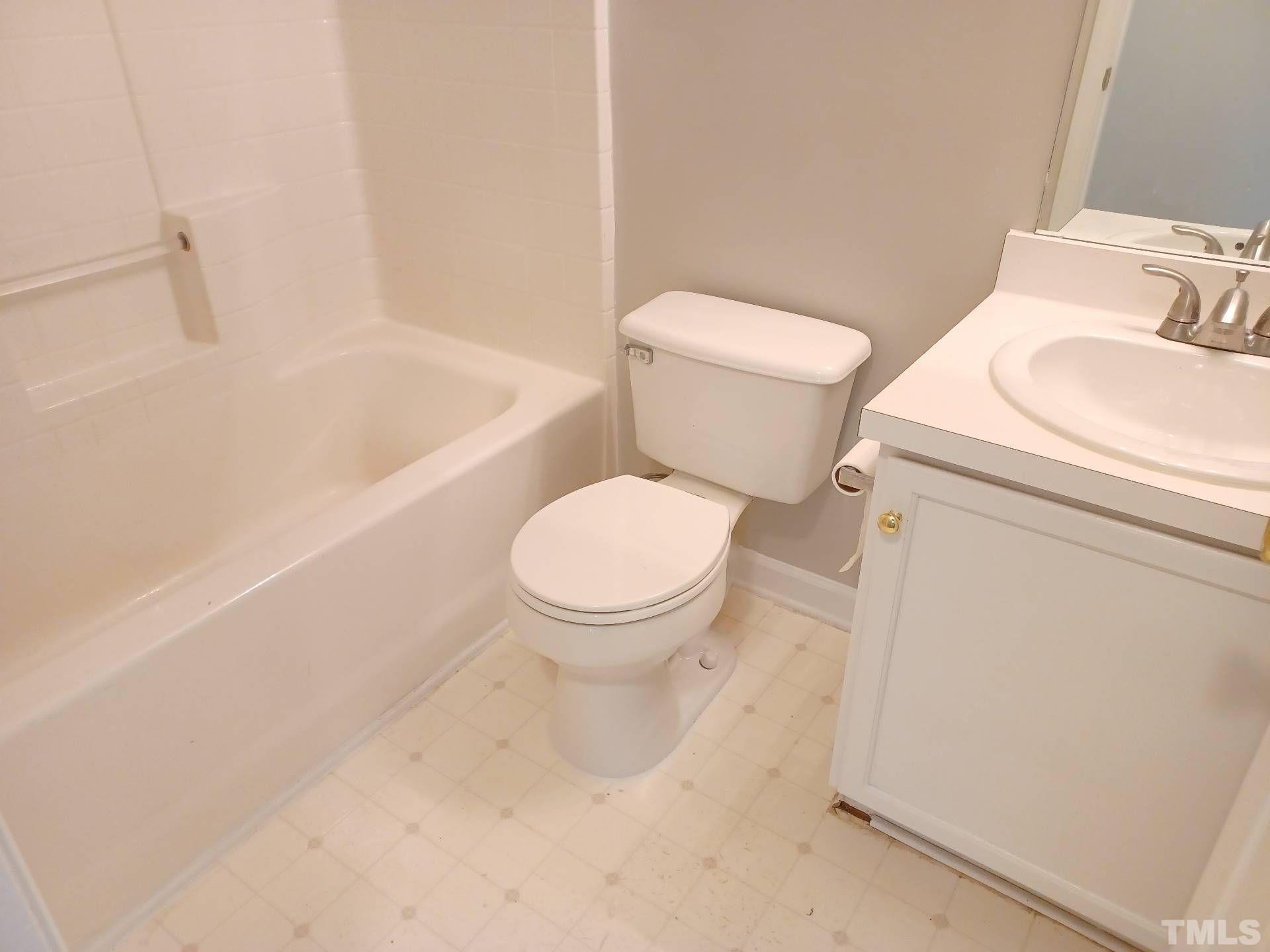 208 Lindell Drive Apex, NC 27539 - Photo 19 of 27 a white toilet sitting next to a bath tub