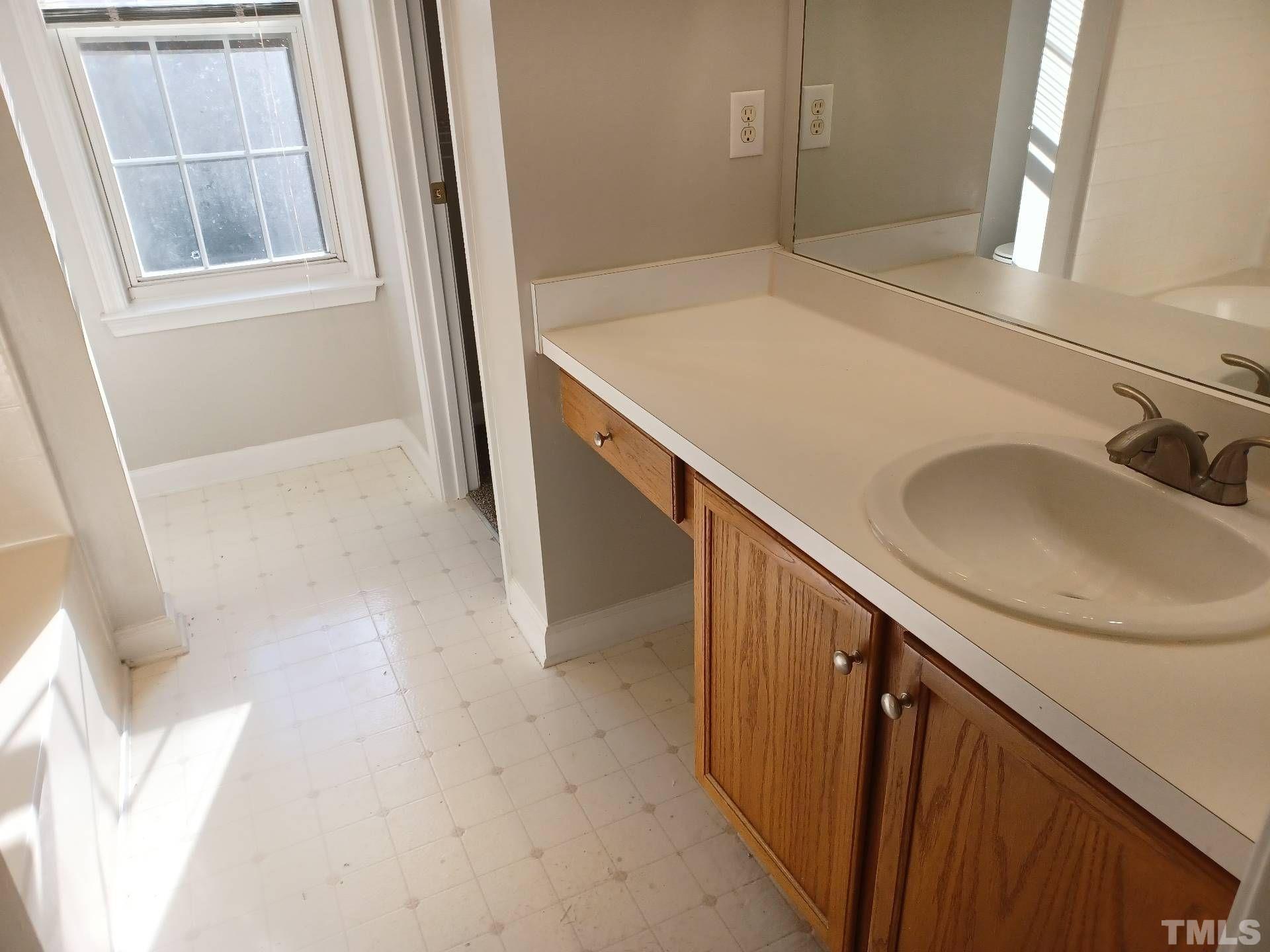 208 Lindell Drive Apex, NC 27539 - Photo 22 of 27 a bathroom with a sink and a mirror