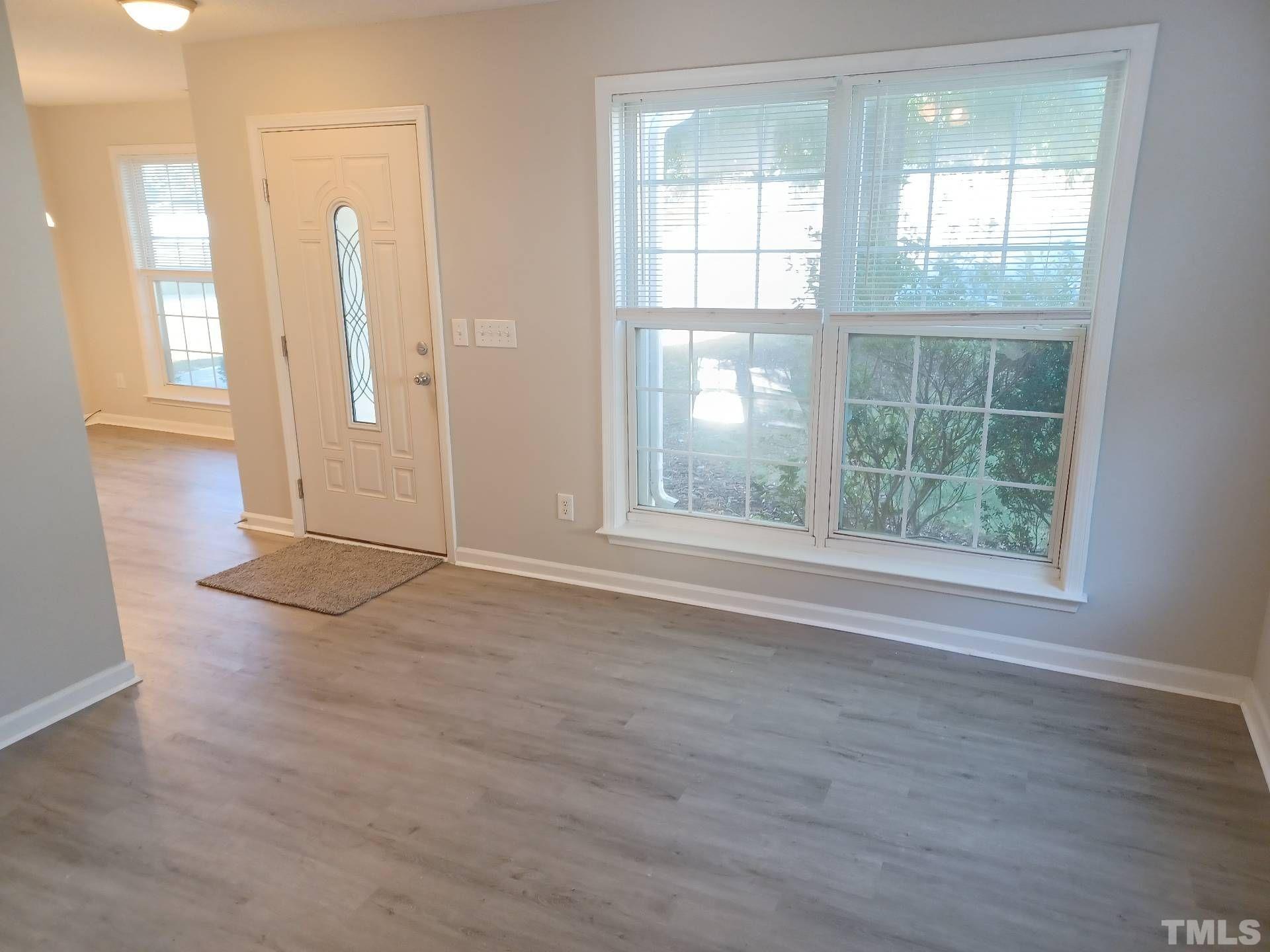 208 Lindell Drive Apex, NC 27539 - Photo 5 of 27 an empty room with wooden floor and windows