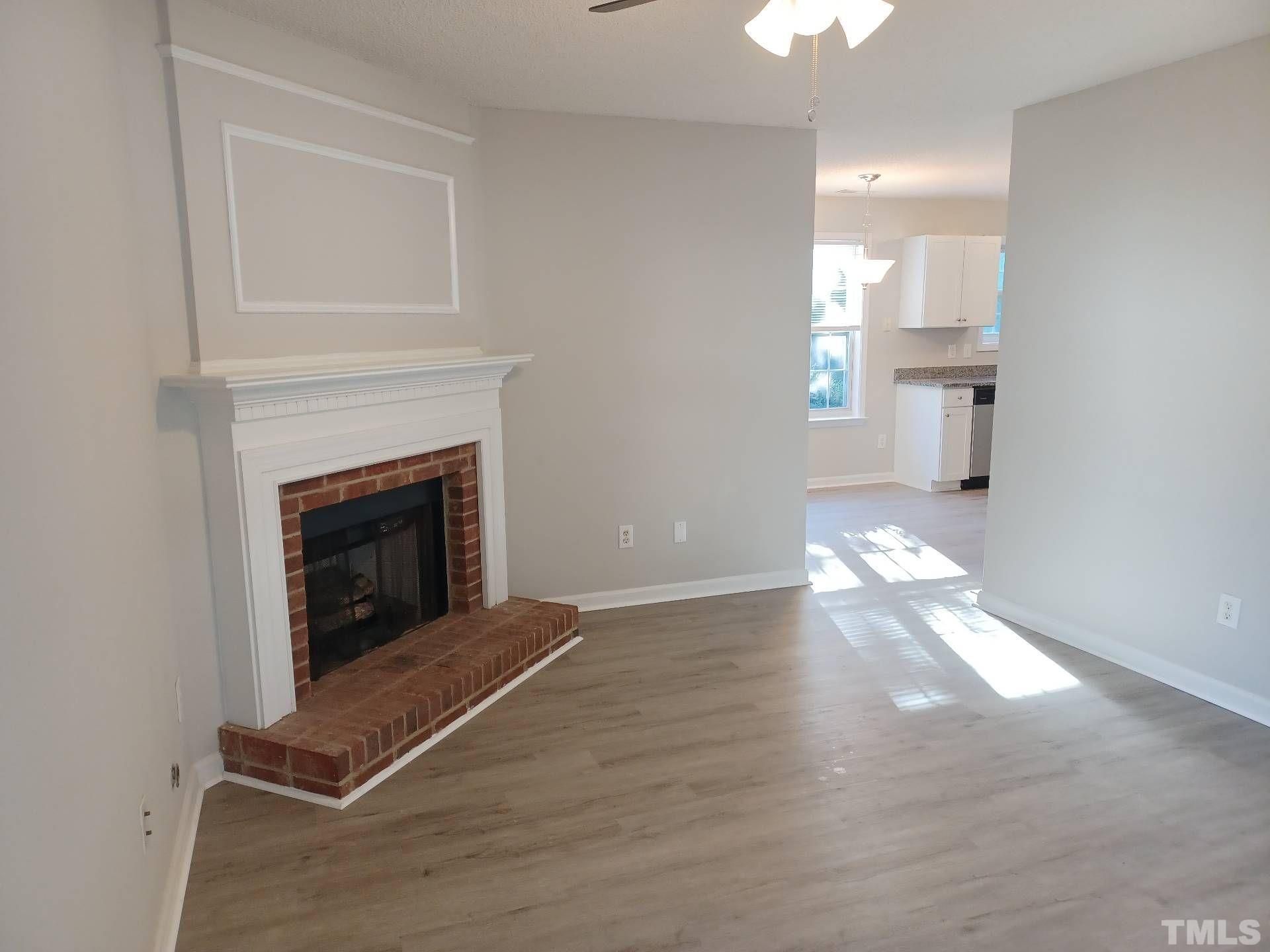 208 Lindell Drive Apex, NC 27539 - Photo 7 of 27 a view of a livingroom with wooden floor and a fireplace