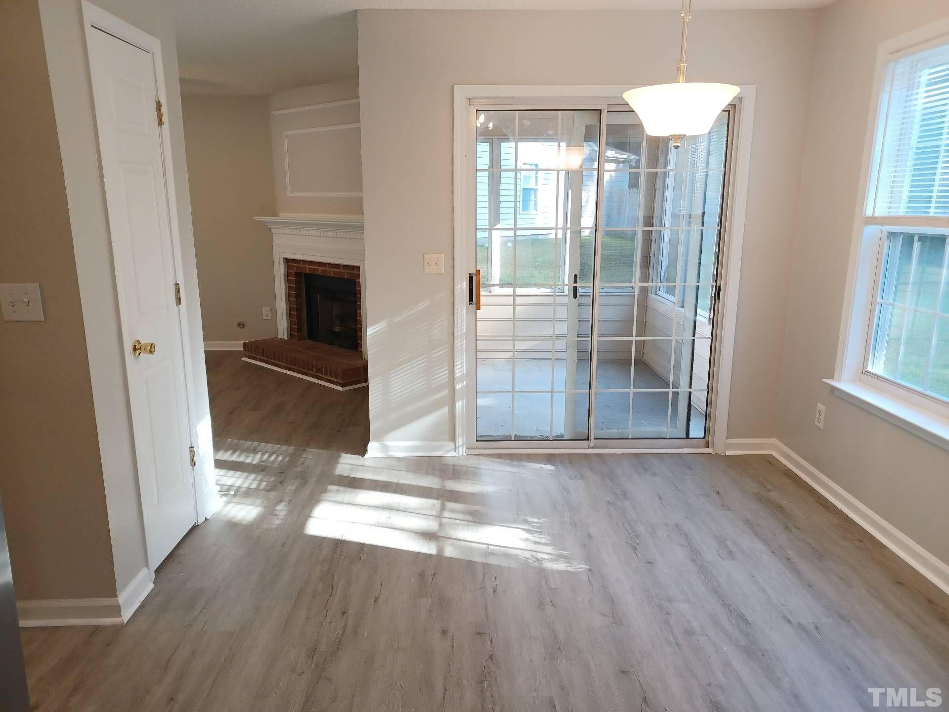 208 Lindell Drive Apex, NC 27539 - Photo 8 of 27 an empty room with wooden floor and a fireplace