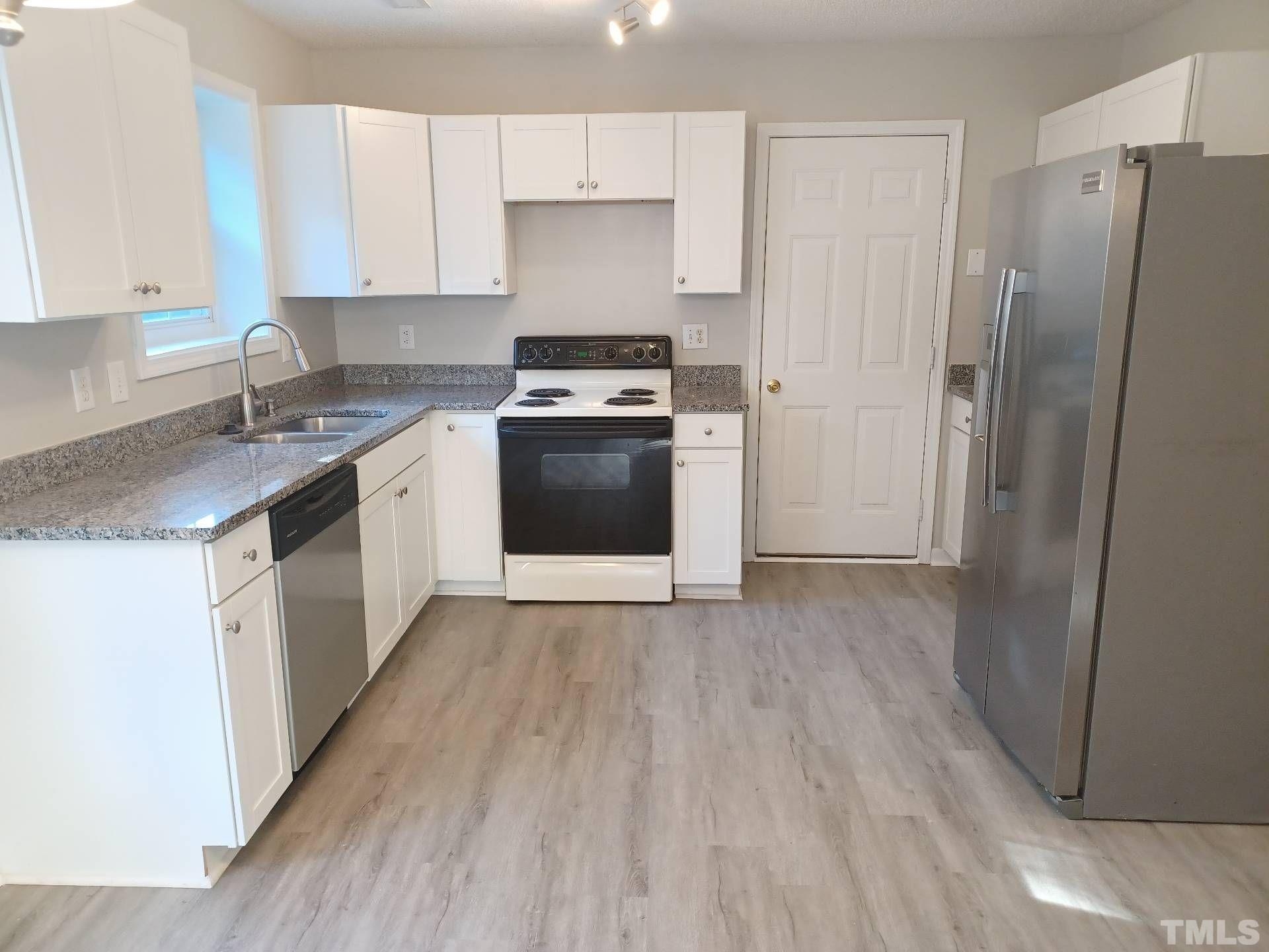 208 Lindell Drive Apex, NC 27539 - Photo 9 of 27 a kitchen with a refrigerator sink and cabinets