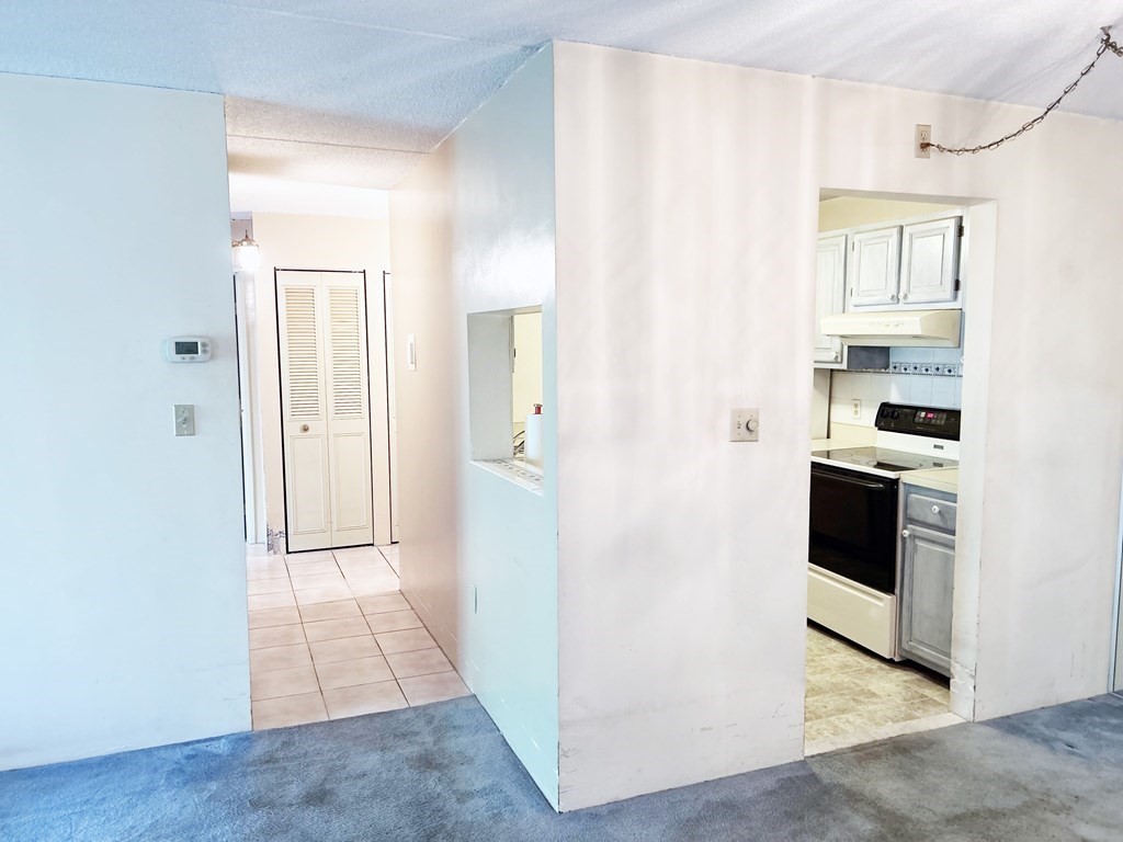 111 Devir Street, Unit 402 Malden, MA 02148 - Photo 6 of 19 a view of a hallway with kitchen and wooden floor