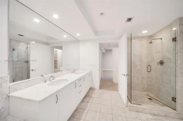 a large bathroom with a double vanity sink mirror and shower