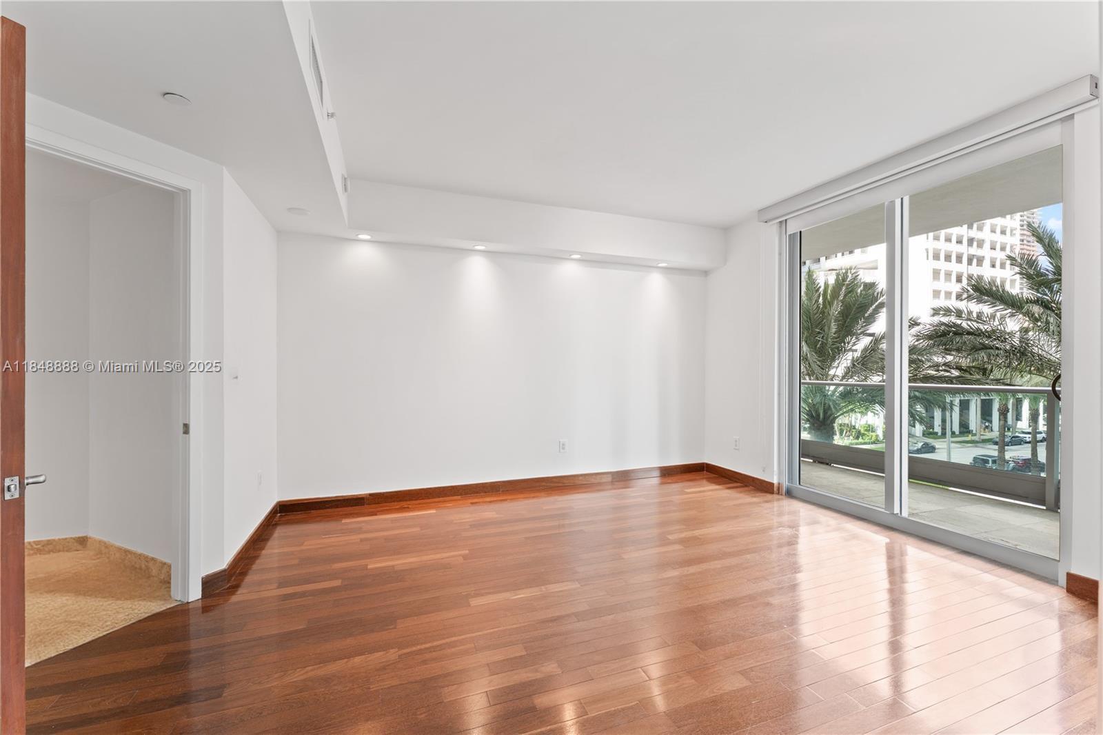 1331 Brickell Bay Drive, Unit 208 Miami, FL 33131 - Photo 18 of 29 a view of an empty room with wooden floor and a window
