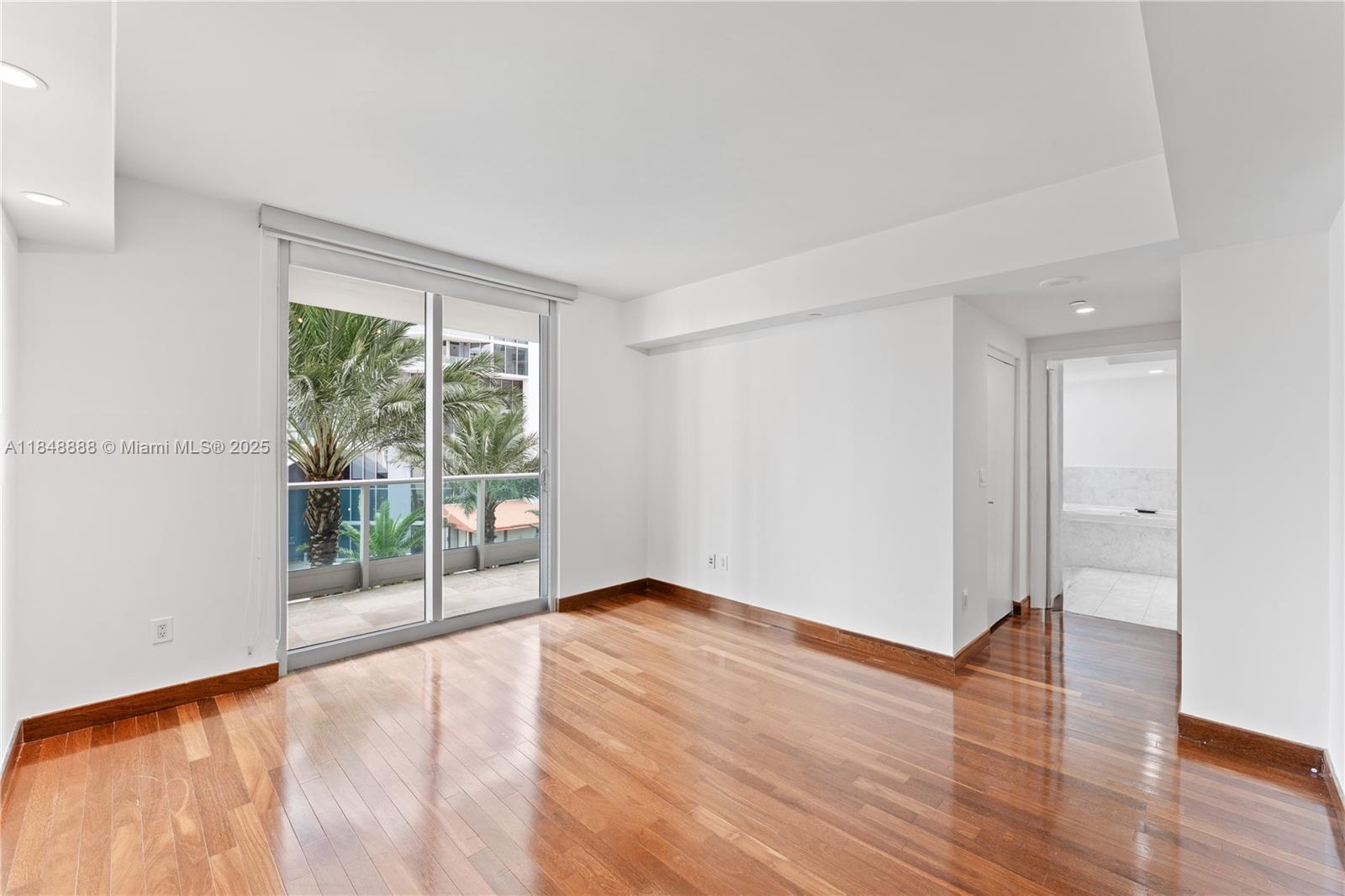 1331 Brickell Bay Drive, Unit 208 Miami, FL 33131 - Photo 19 of 29 a view of an empty room with wooden floor and a window