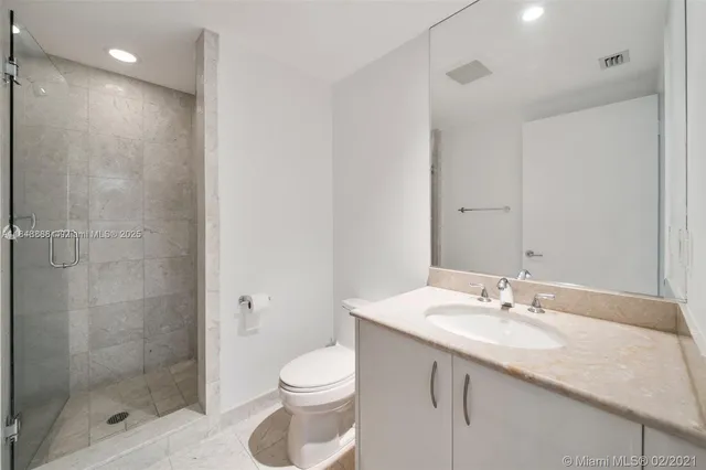a bathroom with a granite countertop sink a toilet and shower