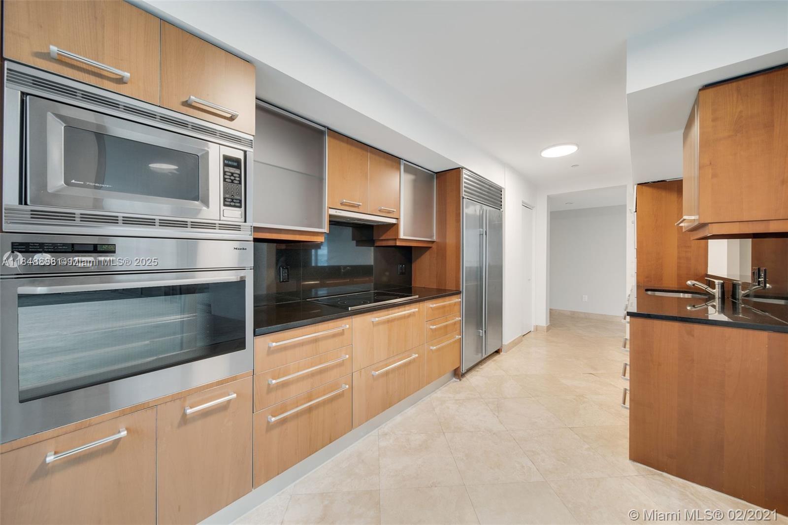 1331 Brickell Bay Drive, Unit 208 Miami, FL 33131 - Photo 7 of 29 a kitchen with stainless steel appliances granite countertop a stove and a microwave