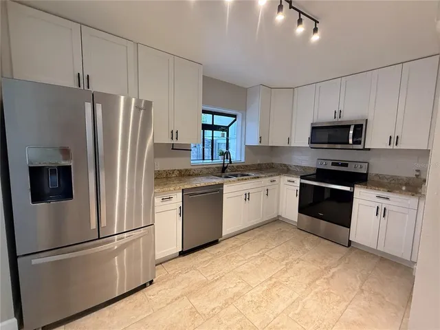 a large white kitchen with a large window