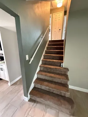 an empty room with wooden floor and a ceiling fan