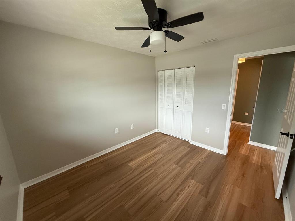 502 Oakhurst Street Brandon, FL 33511 - Photo 25 of 40 an empty room with wooden floor and a ceiling fan