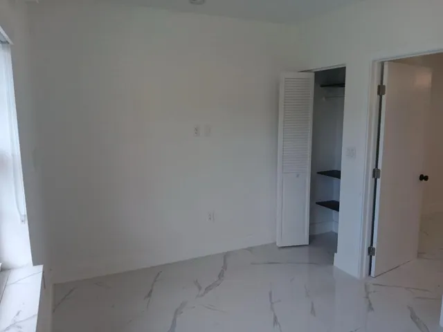 an empty room and a bathroom