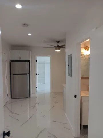 a view of a kitchen with a refrigerator and wooden floor
