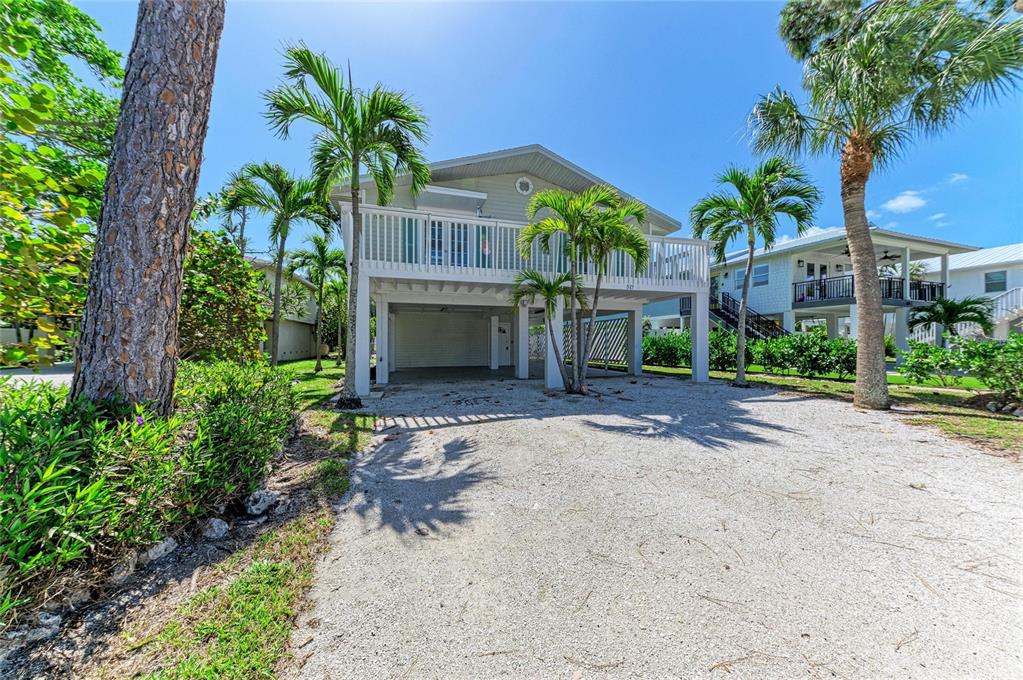 517 Spring Avenue Anna Maria, FL 34216 - Photo 1 of 50 a front view of a house with a yard and a garden