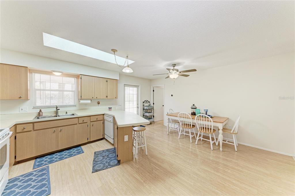 517 Spring Avenue Anna Maria, FL 34216 - Photo 15 of 50 a kitchen with a dining table chairs and white cabinets