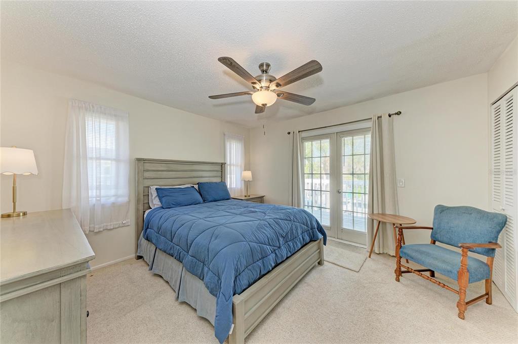 517 Spring Avenue Anna Maria, FL 34216 - Photo 20 of 50 a bedroom with a bed a chair and a large window