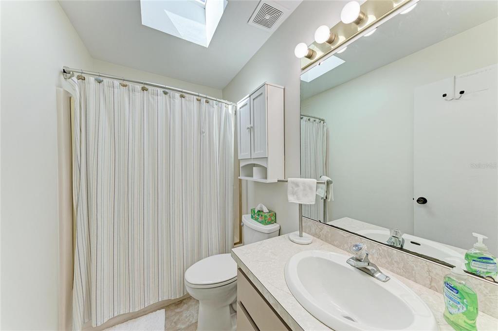 517 Spring Avenue Anna Maria, FL 34216 - Photo 27 of 50 a bathroom with a sink a toilet and shower curtain