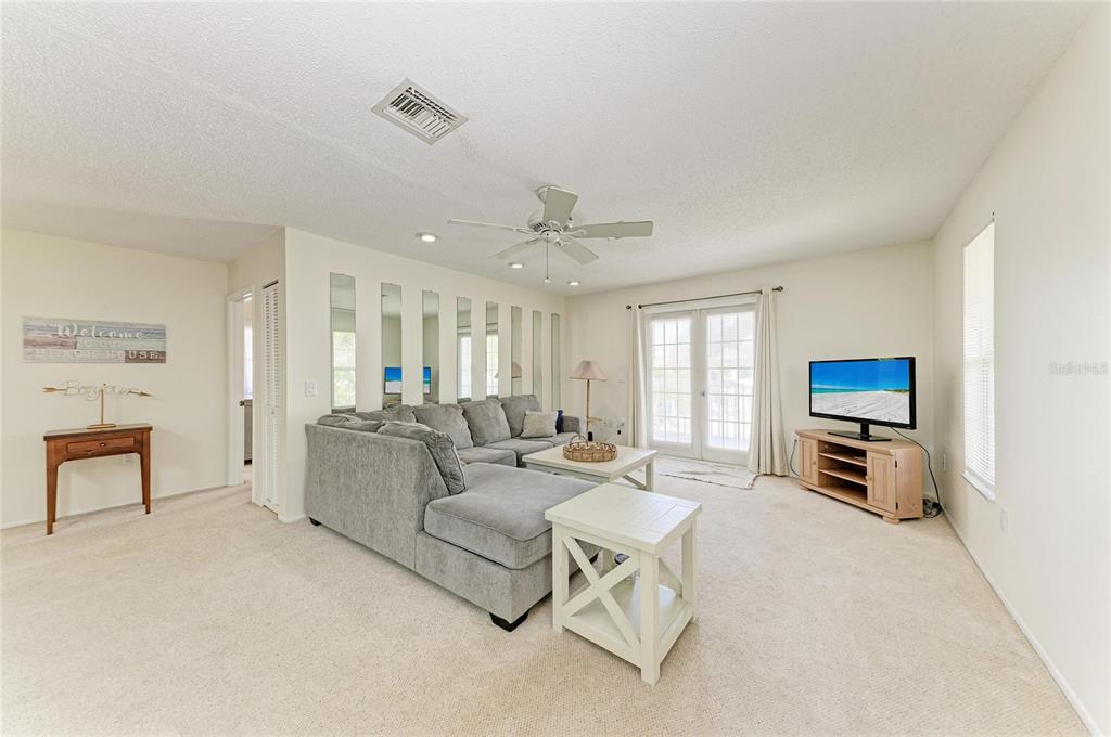 517 Spring Avenue Anna Maria, FL 34216 - Photo 9 of 50 a living room with furniture and a flat screen tv