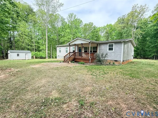 a view of a house with backyard and trees