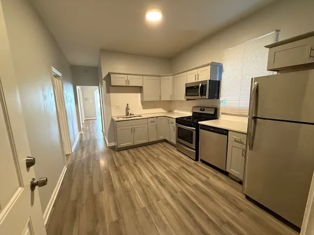 a kitchen with granite countertop a refrigerator stove top oven and sink