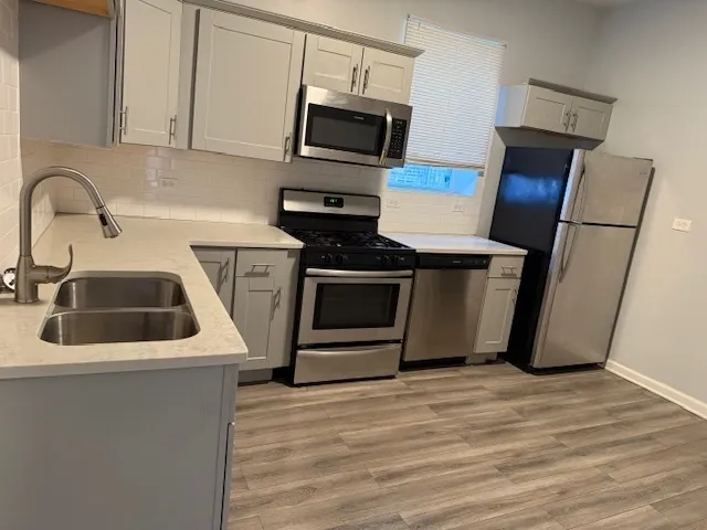 a kitchen with stainless steel appliances a stove a microwave and a sink