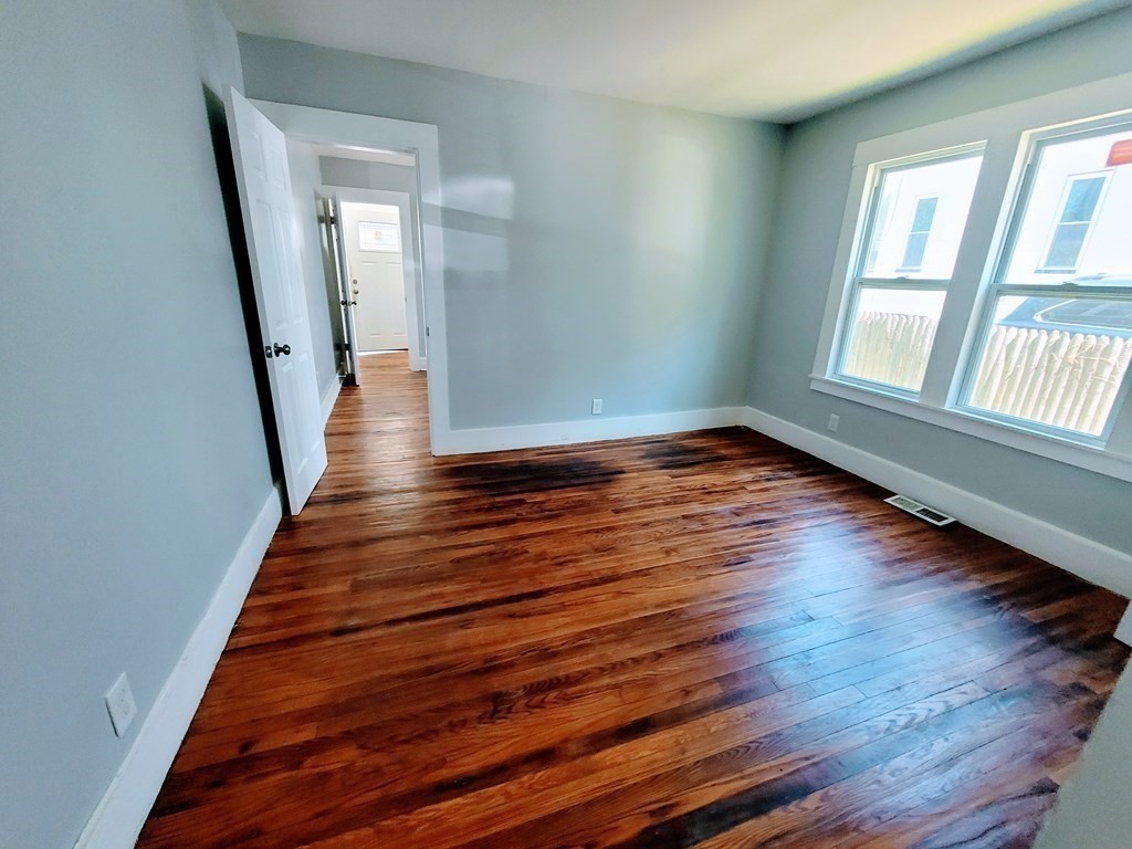 33-35 Algonquin Place Springfield, MA 01104 - Photo 2 of 10 a view of an empty room with wooden floor and a window