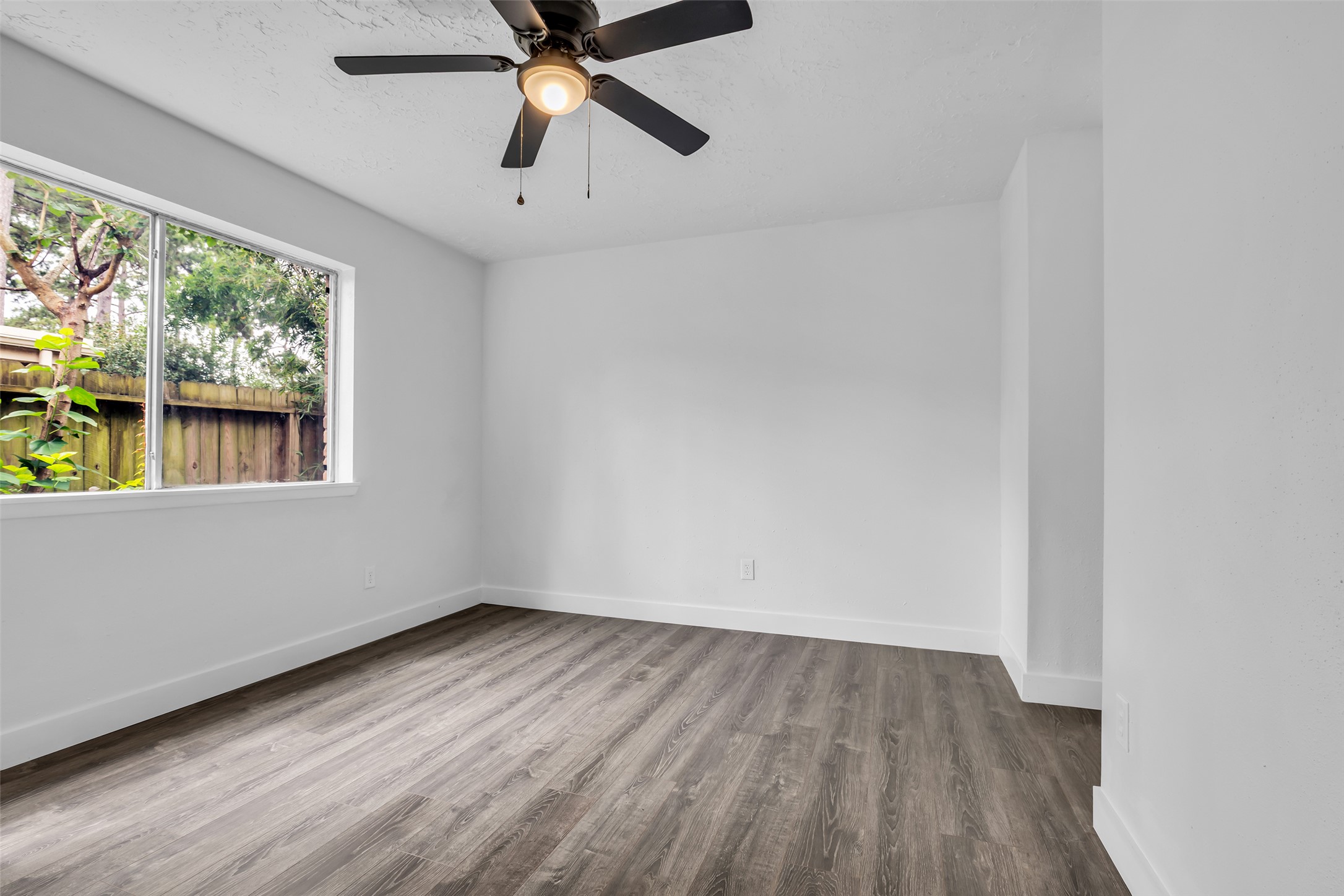 4631 Enchanted Rock Lane Spring, TX 77388 - Photo 10 of 12 A well-lit bedroom with modern flooring offers a peaceful retreat, overlooking a private fenced yard.