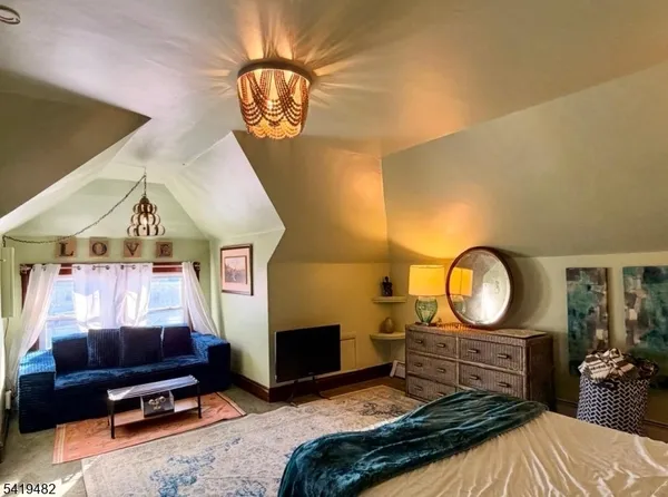 a living room with furniture a mirror and a flat screen tv