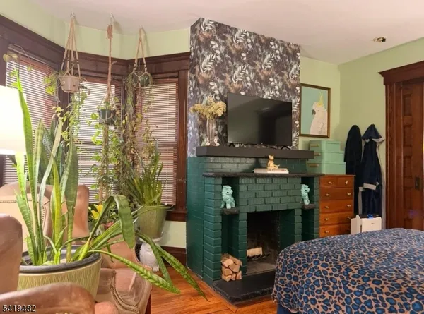 a bedroom with a bed a flat screen tv and a fireplace