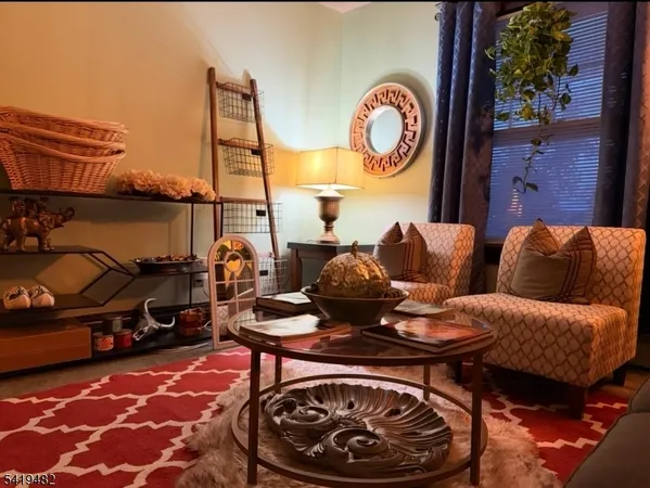a living room with furniture a rug and a lamp