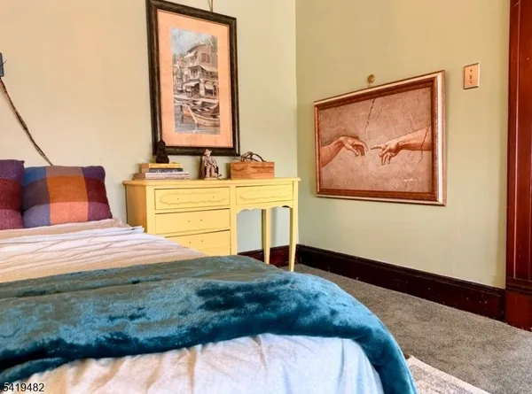 a bedroom with a bed and a painting on the wall