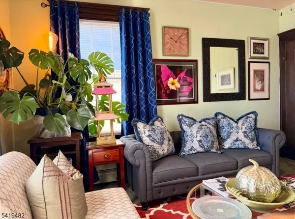 a living room with furniture and a potted plant