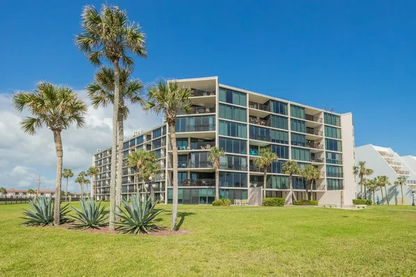 a front view of a building with a garden