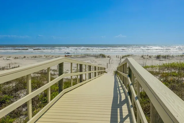 a view of swimming pool with outdoor seating and house in the background