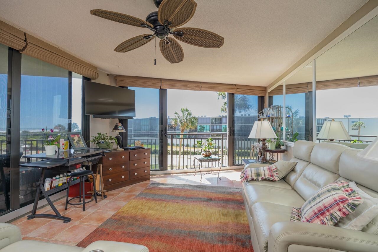 2 Dondanville Road, Unit 304 St. Augustine, FL 32080 - Photo 3 of 43 a living room with furniture a flat screen tv and a floor to ceiling window
