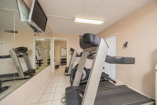 a dining room with furniture a chandelier and large windows